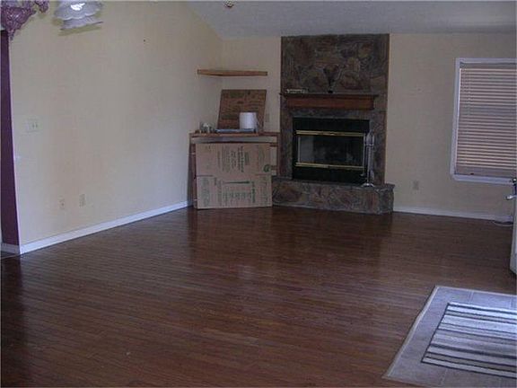  living room has wood burning fireplace and corner cabinet for large TV