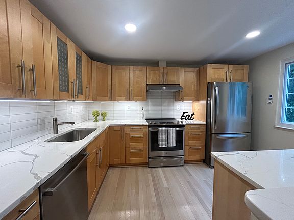 Updated clean kitchen with calacatta countertop, subway tile backsplash, and stainless steel appliances.