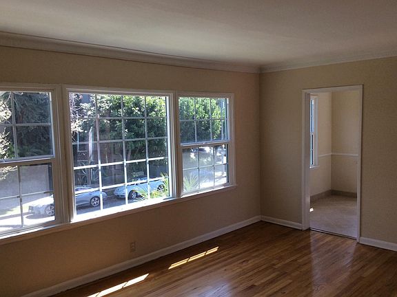 Livingroom with large windows looking into dining area