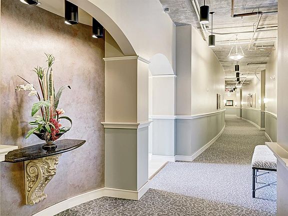 Elegant decorated and wide hallway leads to your next condo unit.