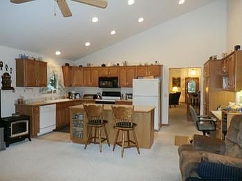 Check out this kitchen with vaulted ceilings.  It has tile in the kitchen and carpet in the great room area.