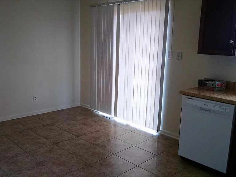 Eating area in large kitchen w/ sliding door out to patio and door out to garage.