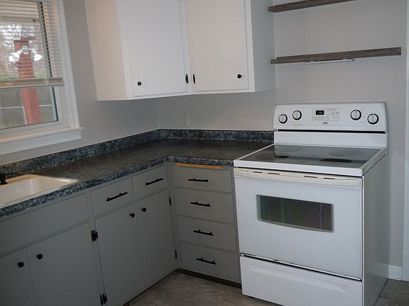 Comfortable kitchen, range, window overlooking back yard.