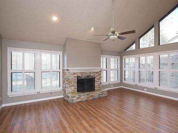 Stone fireplace, high ceilings and plantation shutters make this Family room gorgeous!