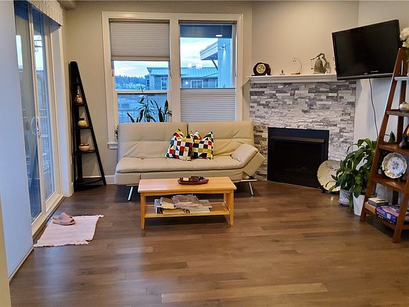 Bright and comfortable Living room. Sliding door to the deck and the window faces West for view of the village and beautiful sunset!
