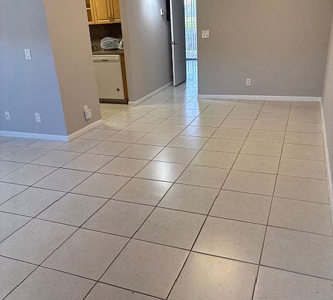 Front door view of dining area on right, kitchen entrance on left and hallway leading to bedroom.