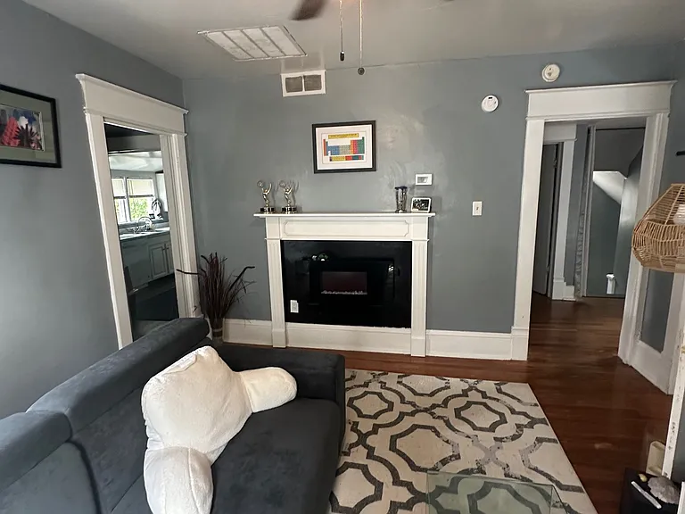 Previous Photo prior to new paint - Living Room w/ New Electric Fireplace. Designer Ceiling Fan and Refinished Original Hardwood Floors!
*Apartment has been painted w/ Sherwin Williams French Gray!*