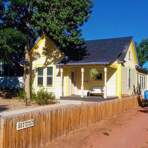 Street view of Vintage bungalow. Fenced front yard and private driveway.