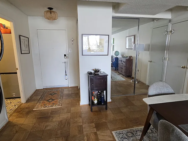 Front door. On the left is the kitchen and on the right is the door to the bedroom and bathroom. The glass doors are the doors to a living room closet.