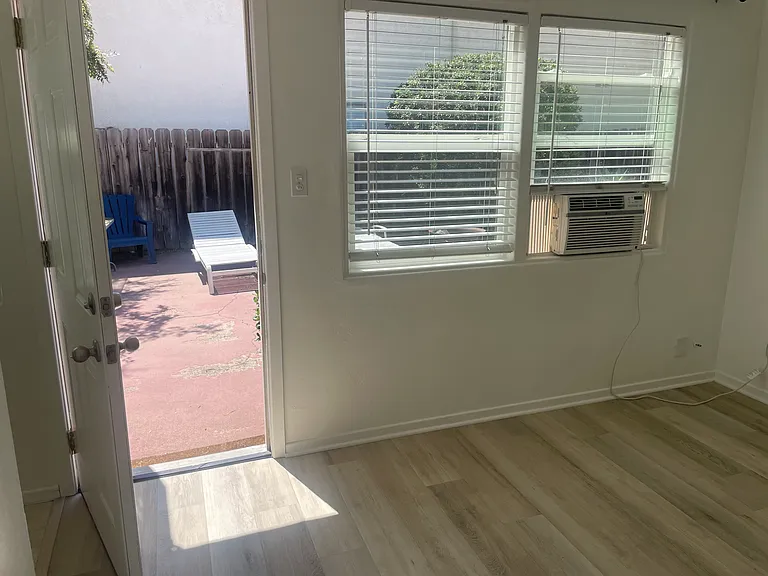 Entry to living room off courtyard. Living room window A/C shown.