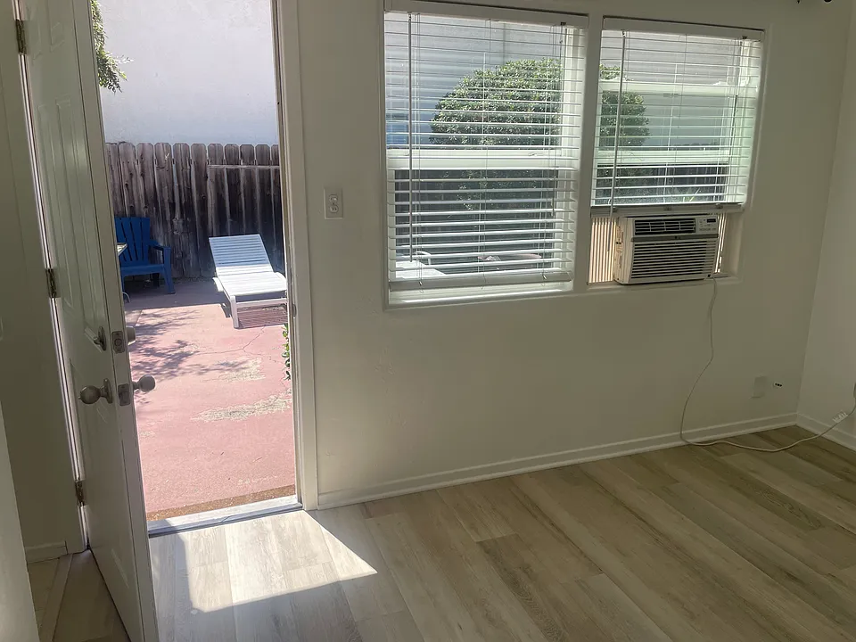 Entry to living room off courtyard. Living room window A/C shown.