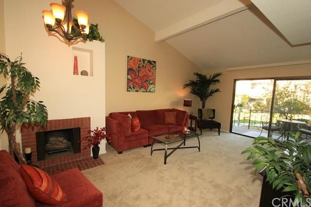 Beautiful living room with tall ceilings, fireplace, and slider looking out onto the huge, grassy courtyard!