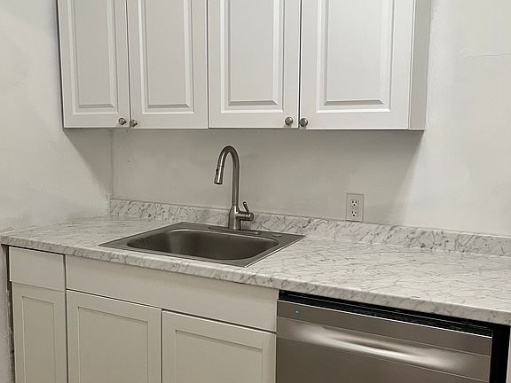 NEW Kitchen sink, countertop, cabinets and stainless steel appliances. Door in the kitchen opens to the backyard and parking.