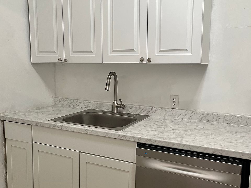 NEW Kitchen sink, countertop, cabinets and stainless steel appliances. Door in the kitchen opens to the backyard and parking.