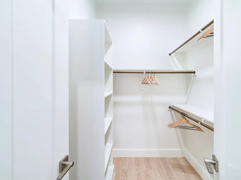 Spacious closet with built-in shelving and dual hanging space designed for organization and streamlined daily routines.