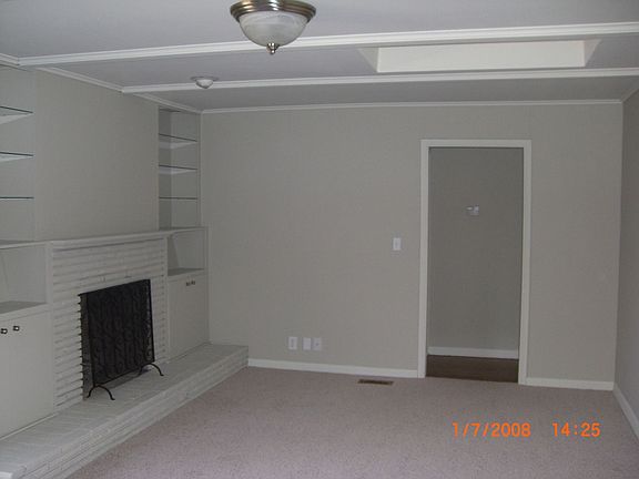 Large living area with skylight, fireplace & new carpet.