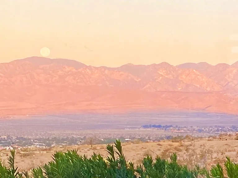Sunrise with full moon setting over the mountains