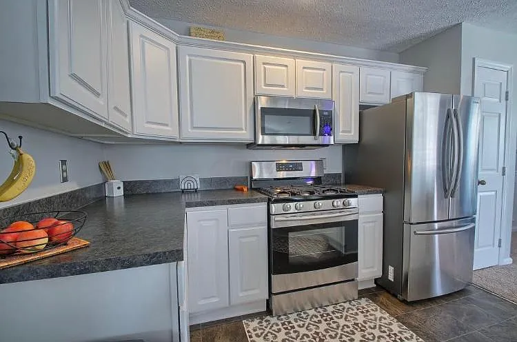 Gas range, stainless steel oven and microwave, and huge double-door refrigerator with dual layered drawer freezer. Plenty of counter space and storage in cabinets.