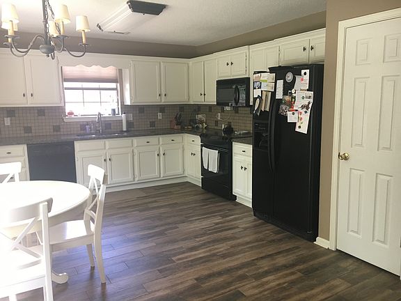 Kitchen w all appliances, quartz countertops and wood look t