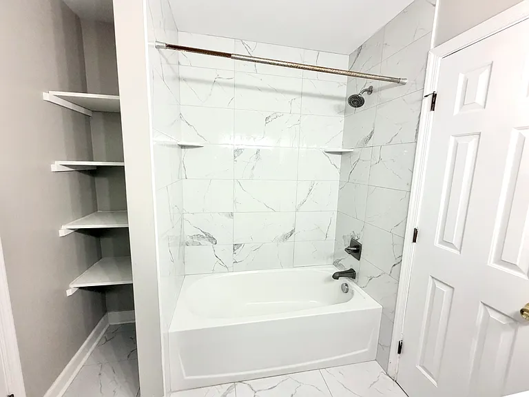 Newly remodeled full bathroom and additional linen and shelving area