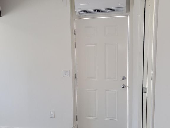 The entry door to the unit and shows mini split for heating and cooling
