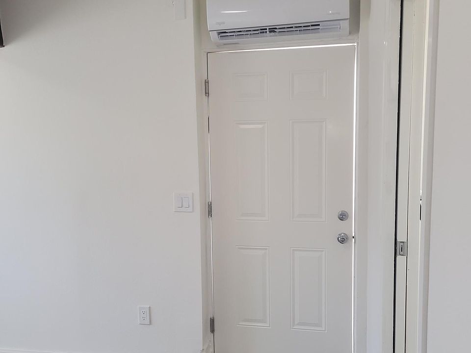 The entry door to the unit and shows mini split for heating and cooling