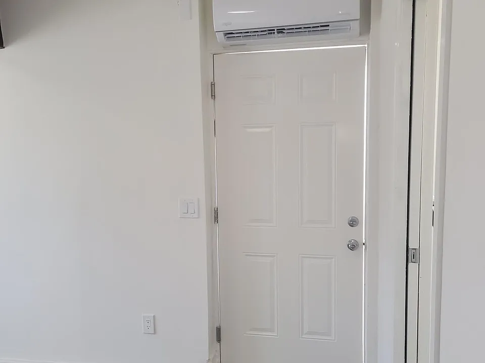 The entry door to the unit and shows mini split for heating and cooling