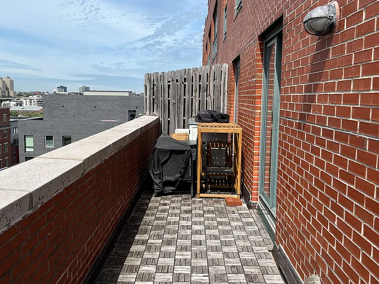 One side of the terrace where outdoor furniture and storage shed are kept
