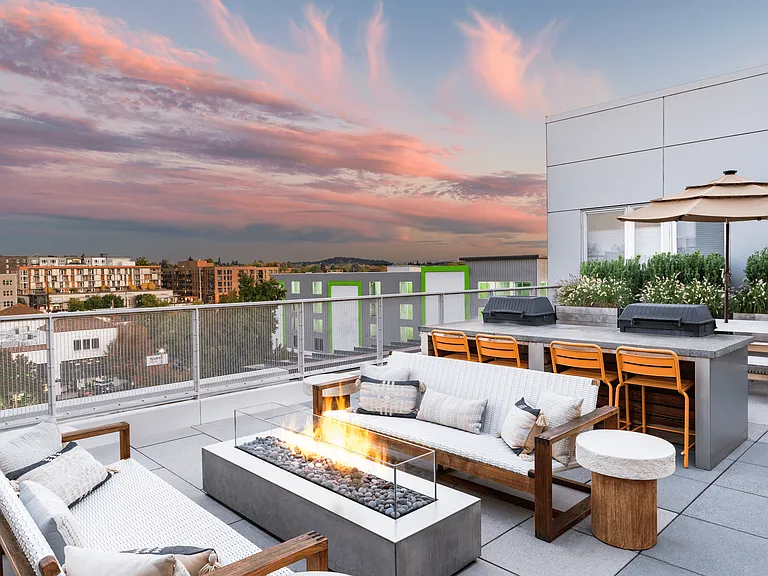 A rooftop gathering space at Modera Belmont, featuring fire tables and skyline views, just moments from Belmont's shops, dining, and nightlife.