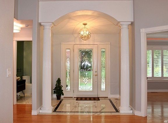 High ceiling archway with pillars to accent the marble entryway.