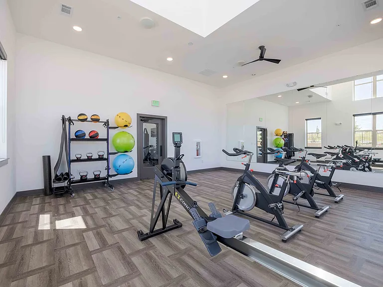 A dedicated studio at Garrett Parker houses cycling bikes, a rowing machine, and free weights, giving residents space for group classes or solo workouts.