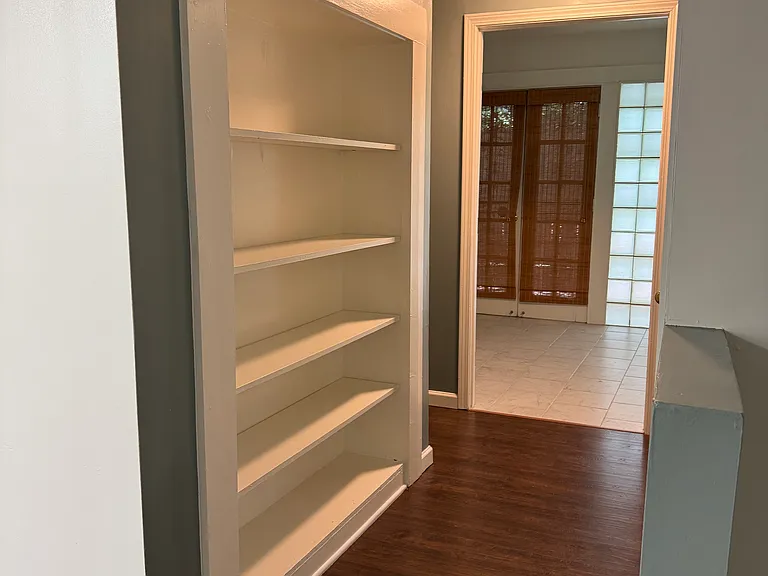 Built-in bookshelf in hallway from living room to kitchen area.