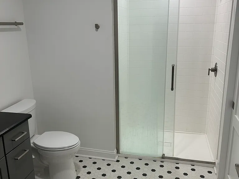 walk in shower with sliding glass door. Tile floor.