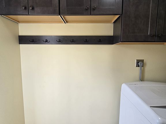 Coat hook and bench area next to dryer at side entrance