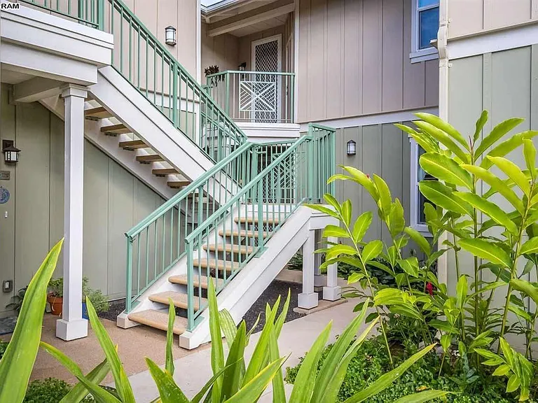 Sidewalk leads to front entry behind the stairs.