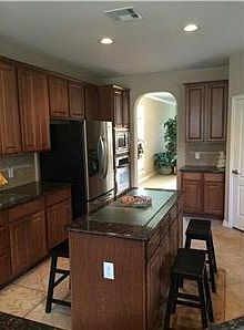 Spacious kitchen with granite countertops, island and stainless