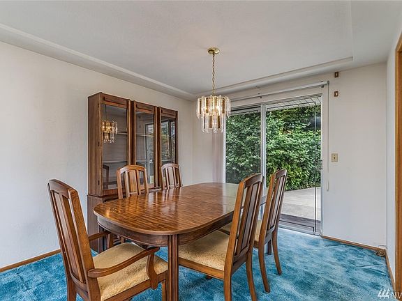 Formal dining area, open to living room, door to the right is the kitchen, and slider to paved patio.
