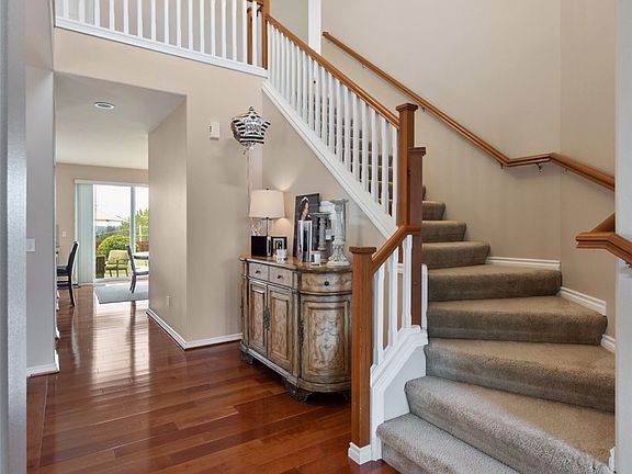 Soaring ceilings, wrap around staircase, hardwood floors makes for a beautiful entrance to this Lakeland Hills home. 