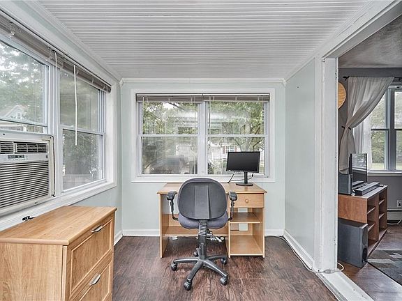 Bright sunroom with barn door and laminate flooring. Sliding glass doors lead to the large deck outside.