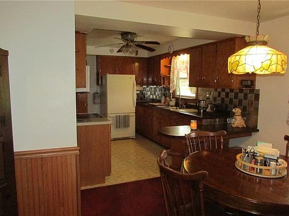 Oak kitchen with appliances and dining area.