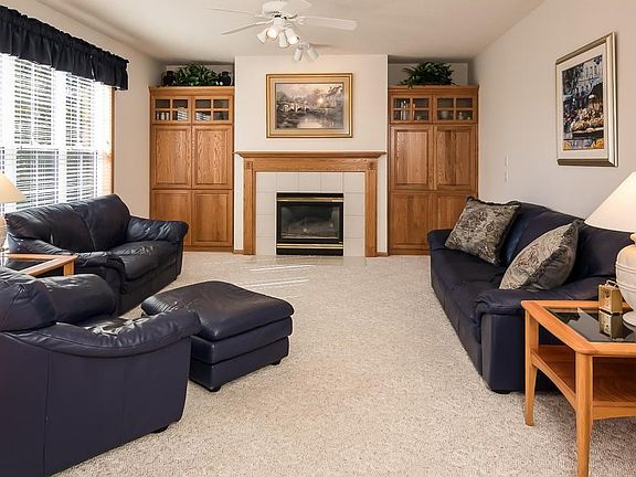 Family room with built-ins, gas fireplace and large windows with views of the backyard