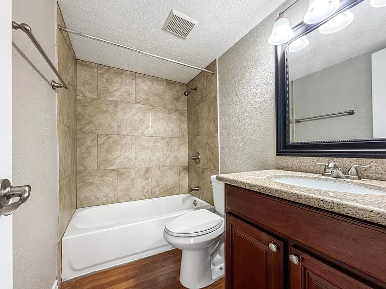 Stylish bathroom featuring vanity and tile shower at Borders Apartments Brownsville TX.