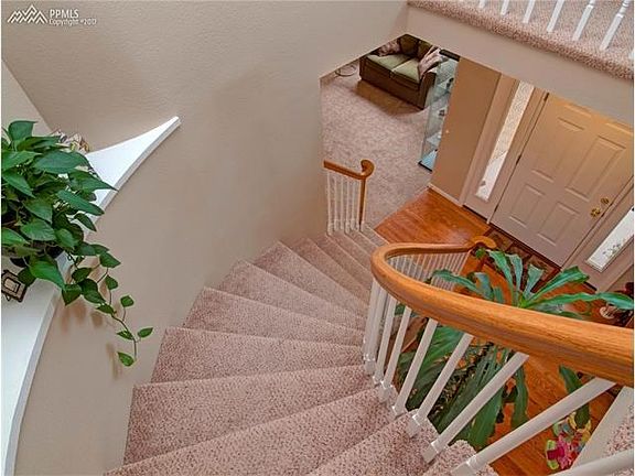 Entryway with quality wood floors and a beautifully curved staircase.