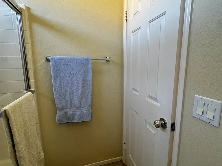 Bathroom with private door separating shower/tub/toilet from sink vanity area. Towel door rack provided