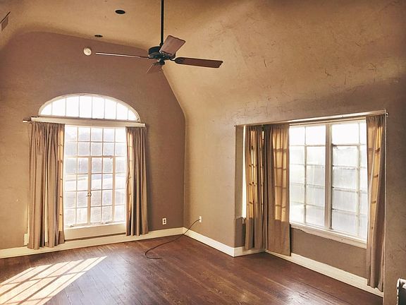 Living room with vaulted ceilings and original floors