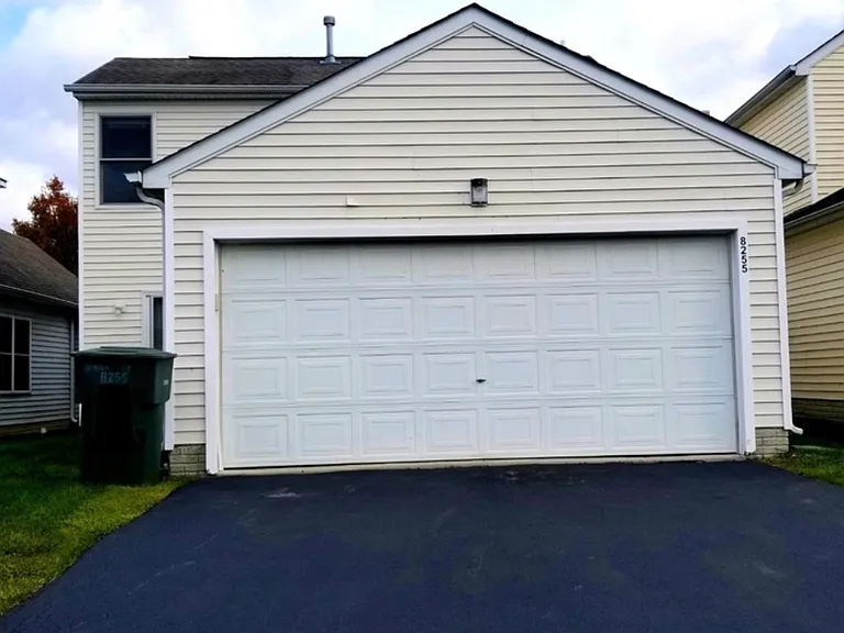 back of the house with 2 car garage and patio