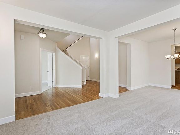 Open floor plan looking from living room into entry way and through dining room into the kitchen.