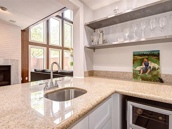Wet Bar - There's a great view of the outdoors from this location too. The fireplace adds ambience to the space and is set in a brick wall with marble tile frame.