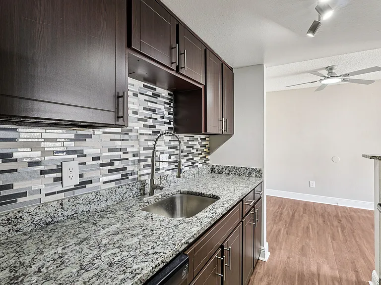 Stylish kitchen featuring granite countertops, mosaic backsplash, and modern cabinetry.