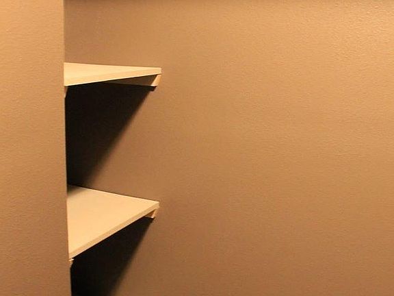 Wood shelving in walk in closet
